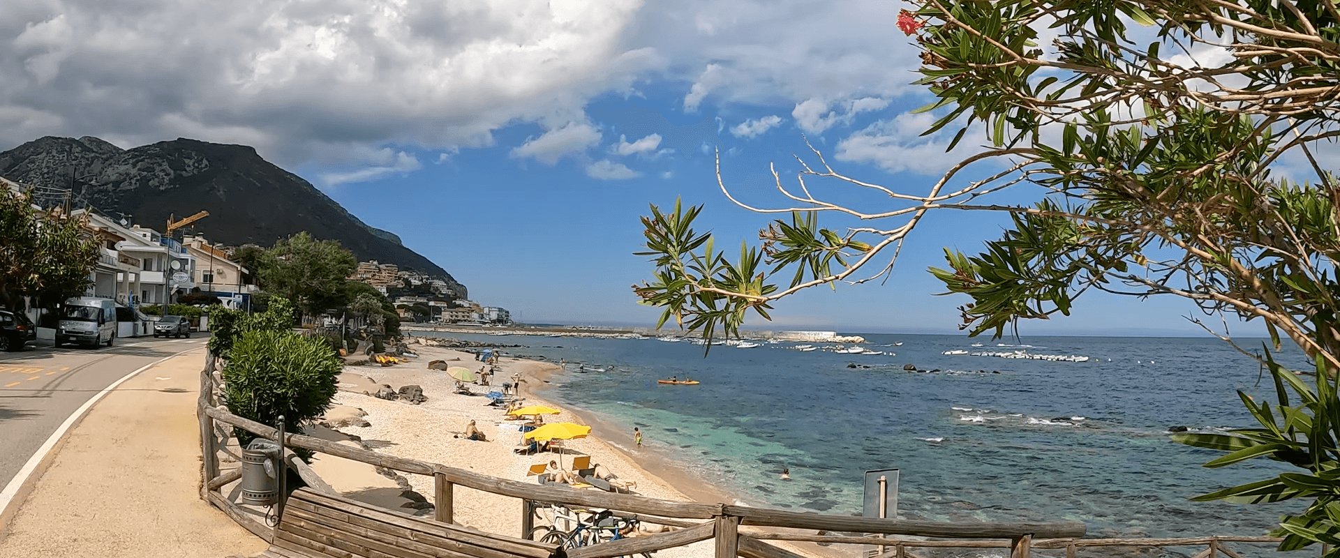 Obrazek banera z widokiem na morze, drzewa, góry i piaszczystą plażę